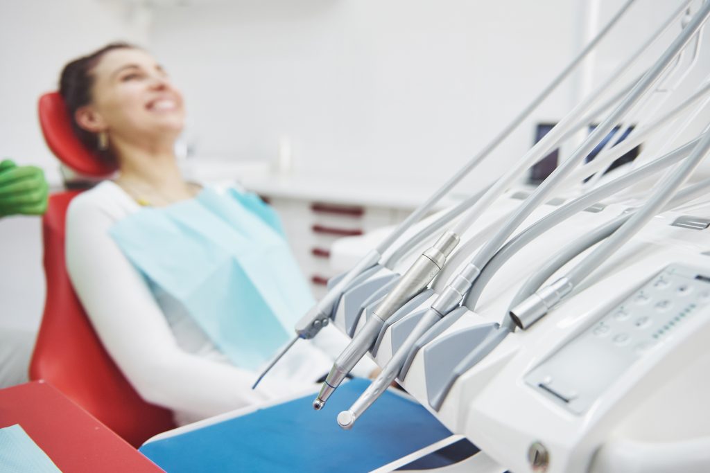 Female patient sitting on dental chair waiting for dental hygiene examination