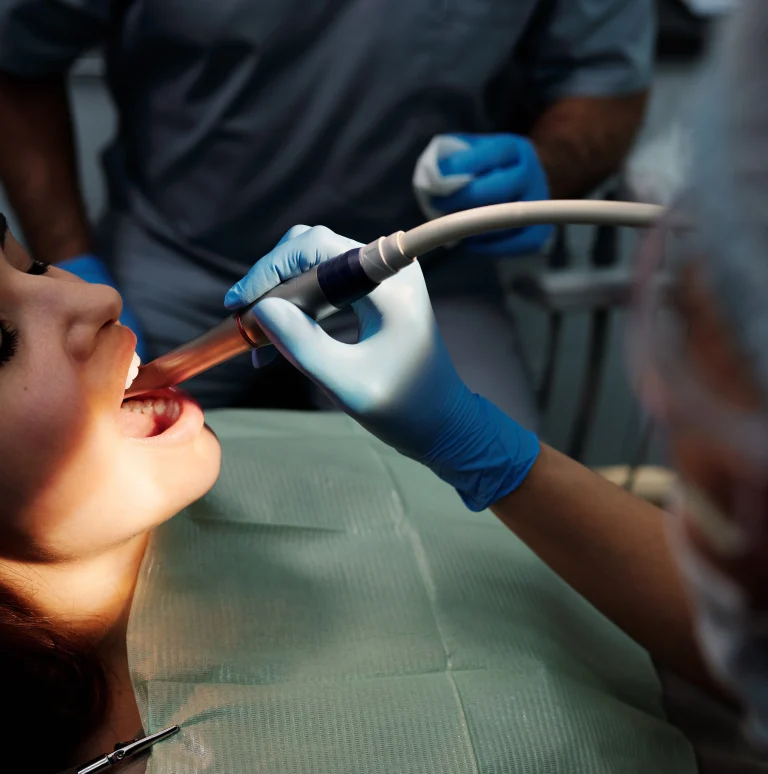 dental hygienist cleaning teeth of a patient