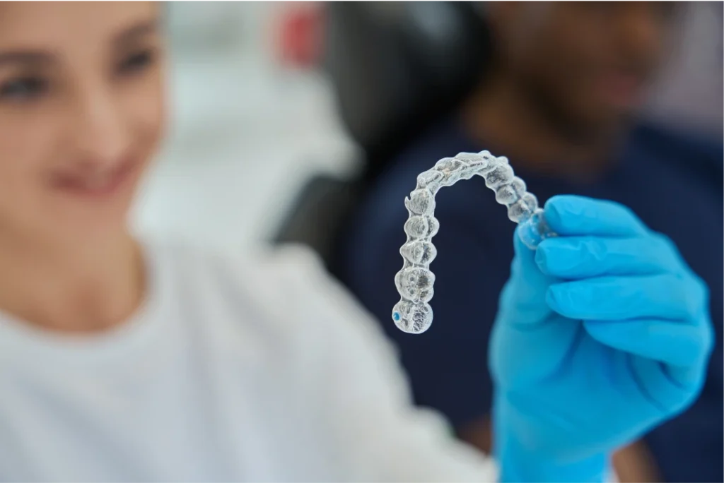 dental technician holding an Invisalign retainer